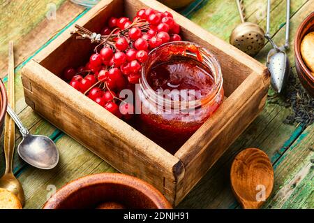 Pot en verre avec confiture et baies de viburnum fraîches Banque D'Images