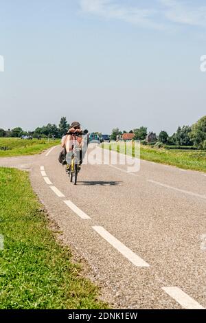 Homme sur vélo couché sur la digue aux pays-Bas Banque D'Images