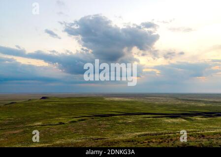 Coucher de soleil pittoresque avec des nuages dans le ciel dans la steppe. Banque D'Images