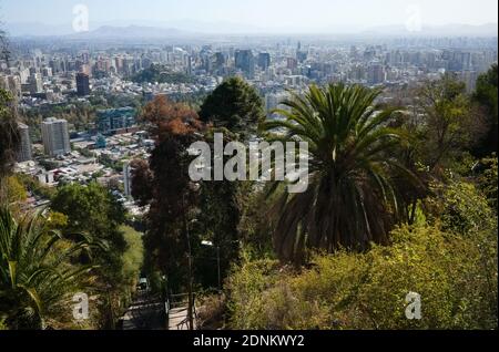 Vue panoramique de la ville de Santiago du Chili depuis la colline de San Cristobal, végétation luxuriante, palmiers et funiculaire. Santiago, Chili Banque D'Images