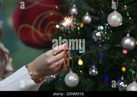 Girl holding a burning sparkler in her hands. Banque D'Images