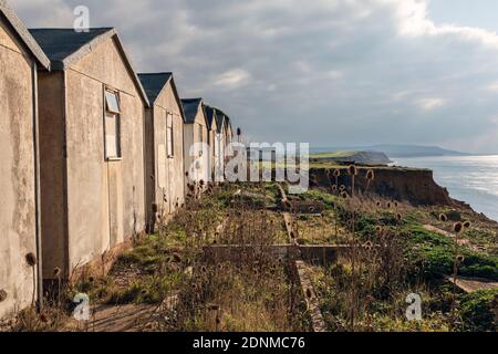 Derelict holiday chalets abandoned because of cliff erosion at Brighstone Bay, Isle of Wight Stock Photo