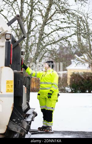 Femme utilisant un camion à ordures Banque D'Images