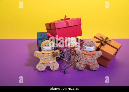 Une famille d'hommes de pain d'épice avec un petit enfant dans des masques de protection avec le shopping dans le supermarché. Banque D'Images