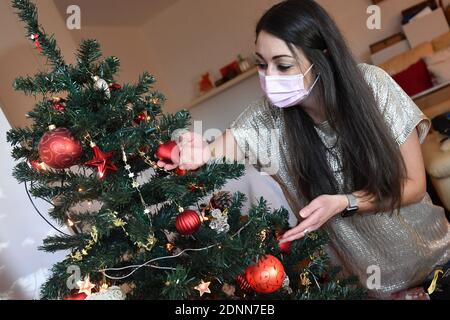 Munich, Allemagne. 17 décembre 2020. Sujet photo Lonely Weihafterten 2020 dans la pandémie du coronavirus: Une jeune femme avec un masque facial, le masque décore son Weihaftertsbaum. Pandémie, verrouillage, shutdown, valeur de l'incidence. MODÈLE DISPONIBLE ! | utilisation dans le monde crédit: dpa/Alay Live News Banque D'Images