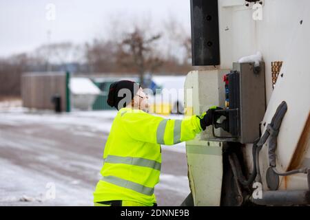 Femme utilisant un camion à ordures Banque D'Images