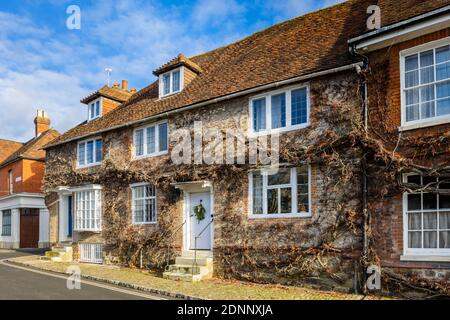 Georgian style terraced cottage (Church Hill House) in Church Hill, Midhurst, West Sussex, in winter with a Christmas wreath on its blue front door Banque D'Images