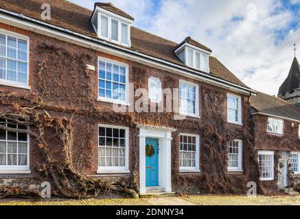 Georgian style terraced cottage (Church Hill House) in Church Hill, Midhurst, West Sussex, in winter with a Christmas wreath on its blue front door Banque D'Images