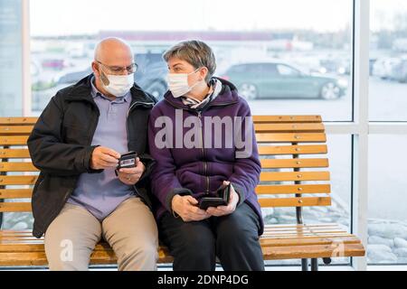 Couple portant un masque de protection assis sur un banc Banque D'Images