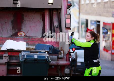 Femme utilisant un camion à ordures Banque D'Images