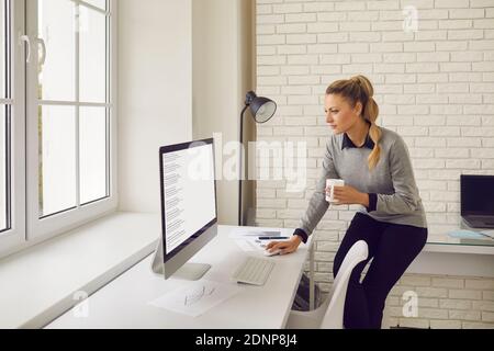 Employé de l'entreprise regardant l'écran de l'ordinateur de bureau et étudiant résultats de la recherche Banque D'Images