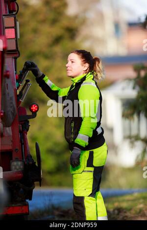 Femme utilisant un camion à ordures Banque D'Images