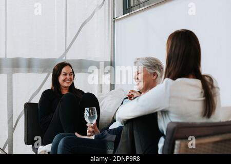 Les petites-filles et la grand-mère des adultes parlent sur le canapé Banque D'Images