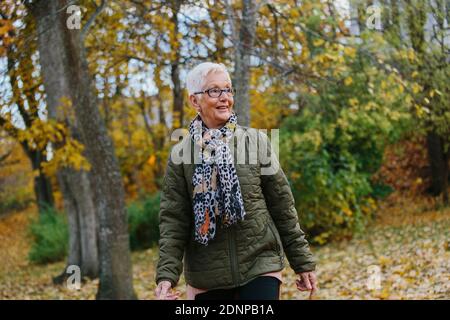 Femme âgée marchant à l'automne Banque D'Images