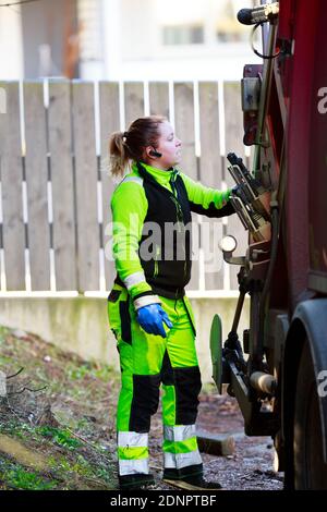 Femme utilisant un camion à ordures Banque D'Images