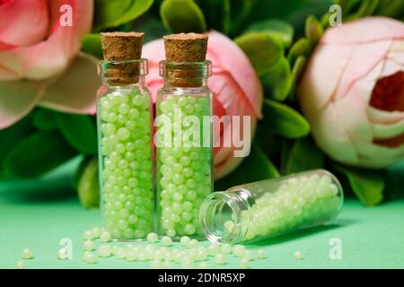 flacons en verre avec granulés verts et roses. remèdes homéopathiques Banque D'Images