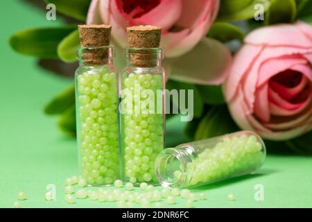 flacons en verre avec granulés verts et roses. remèdes homéopathiques Banque D'Images