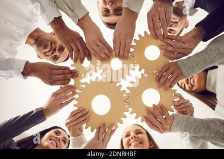 Une équipe de personnes qui se joint à Gears comme métaphore pour un travail d'équipe efficace et trouver une solution de travail Banque D'Images