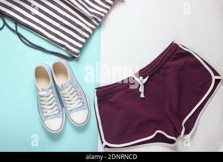 Vêtements et accessoires pour femmes pour le fitness sur fond pastel coloré. Sneaker, short de sport, sac. Style de pose à plat. Vue de dessus Banque D'Images
