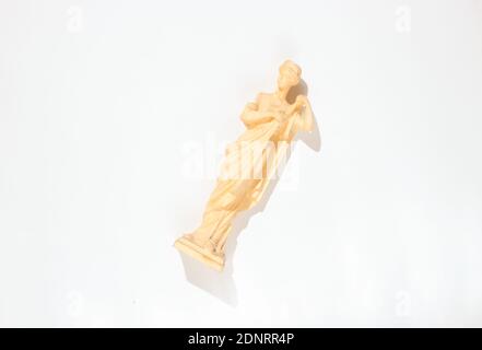 Figurine de l'ancienne déesse sur fond blanc. Photo avec ombres, lumière dure, vue de dessus Banque D'Images