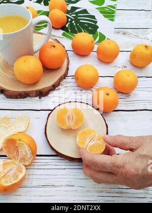 La main de la femme se fait un satsuma Banque D'Images