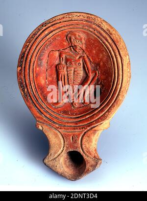 Tonlampe (Crouching beggar), argile, pressée dans le moule, modélisée à la main, argile, total: Hauteur: 2.5 cm; largeur: 9.7 cm; profondeur: 6.7 cm; diamètre: 4.9 cm (Tondo), céramique, éclairage, mendiant, homme, classes sociales/groupes sociaux, les pauvres, période impériale précoce, période impériale moyenne, Antiquité romaine, la lampe en argile avec un revêtement rougeâtre a une représentation plastiquement mise en évidence dans le tondo. L'image intérieure est entourée de trois cercles incisés. Il montre une figure accroupie avec sa tête tournée vers son côté gauche. La figure est émaciée (ce que l'on appelle le squelette de la peau). Banque D'Images