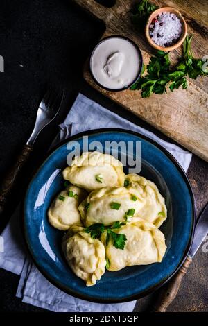 Boulettes de pommes de terre ukrainiennes au varéniki avec garniture de ciboulette et crème aigre Banque D'Images