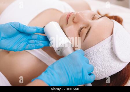 Gros plan d'une jeune femme qui s'affermit de la peau et massage de serrage par esthéticienne Banque D'Images