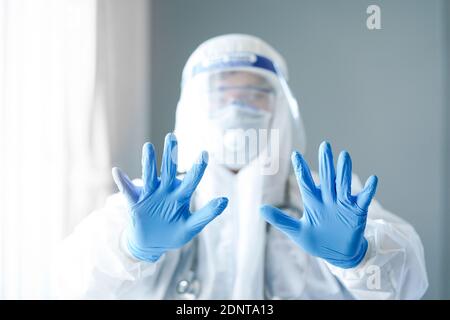Portrait d'un médecin portant un EPI de protection tenant ses mains haut Banque D'Images