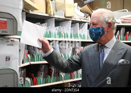 Le Prince de Galles aide à trier les lettres lors d'une visite au bureau de livraison de Royal Mail, à Cirencester, afin de reconnaître les services publics essentiels que les travailleurs postaux du pays fournissent, en particulier cette année et à l'approche de Noël. Banque D'Images