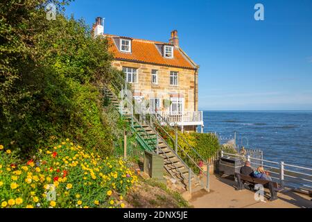 Vue sur les maisons et les couples avec vue sur la mer du Nord, Robin Hood Bay, North Yorkshire, Angleterre, Royaume-Uni, Europe Banque D'Images