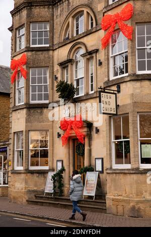 Royaume-Uni, Gloucestershire, Bourton on the Water, High Street, décorations de Noël sur Chip Shed Fish and Chip Shop dans le bâtiment historique en pierre de cotswold Banque D'Images