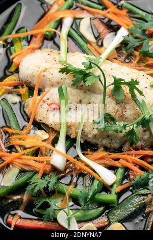 filet de poisson épicé chinois à la vapeur de style cantonais accompagné de légumes plaque chaude Banque D'Images