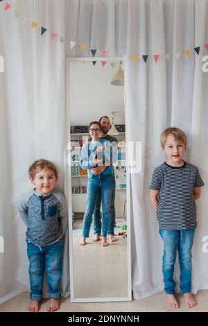 Les garçons regardent les parents qui réfléchit dans le miroir Banque D'Images