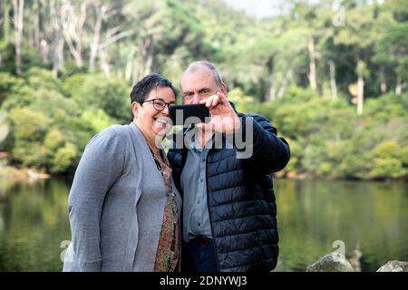 Smiling couple prenant selfies Banque D'Images