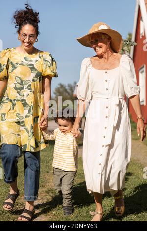 Un tout-petit garçon marchant avec sa mère et sa grand-mère Banque D'Images