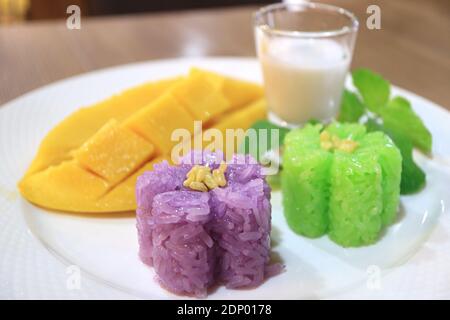 Magnifique riz autocollant en forme de fleur de couleur avec des mûres fraîches et floues Lait de mangue et de noix de coco en arrière-plan Banque D'Images