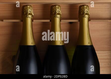 Gros plan de trois bouteilles de champagne dans un coffret en bois. Banque D'Images