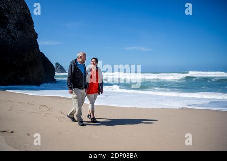 Smiling couple walking on beach Banque D'Images
