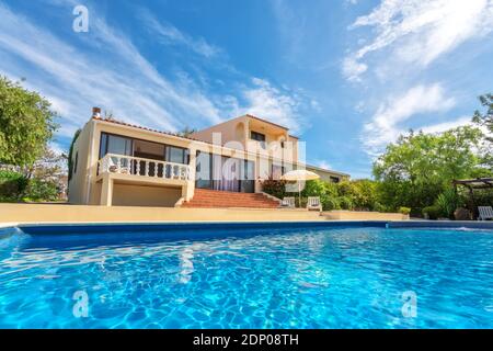 Une piscine de luxe avec de l'eau bleu clair donnant sur le jardin de la villa. À louer aux touristes. Banque D'Images