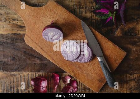 Slices red onion on chopping board Banque D'Images