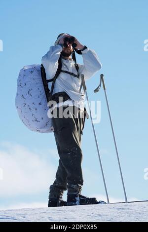 Ski de fond regardant à travers des jumelles Banque D'Images