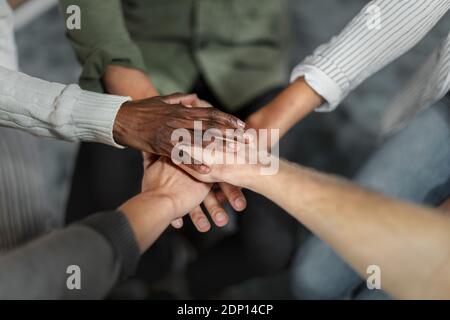 Gros plan d'un groupe de personnes méconnues qui se joignent à leurs mains ensemble en caucus Banque D'Images