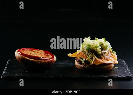 Burger, potatoes, sauce on a black background Stock Photo