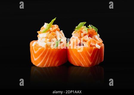 Les sushis japonais roulent sur fond noir Banque D'Images