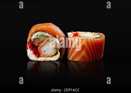 Les sushis japonais roulent sur fond noir Banque D'Images