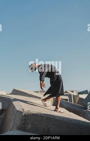 Jeune homme portant un caftan noir en plein air Banque D'Images