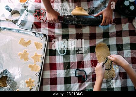 Tête de deux enfants préparant de la pâte à biscuits au sucre à table Banque D'Images