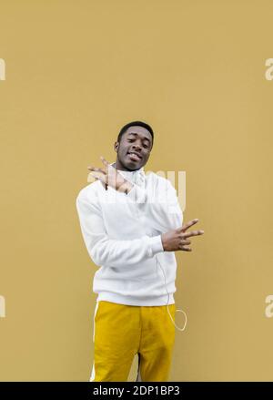 Portrait du jeune homme souriant montrant le signe de la victoire Banque D'Images