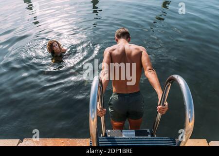 Jeune homme d'entrer dans l'eau de la jetée Banque D'Images